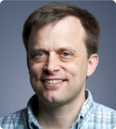 A color photo of a man smiling for a photo.