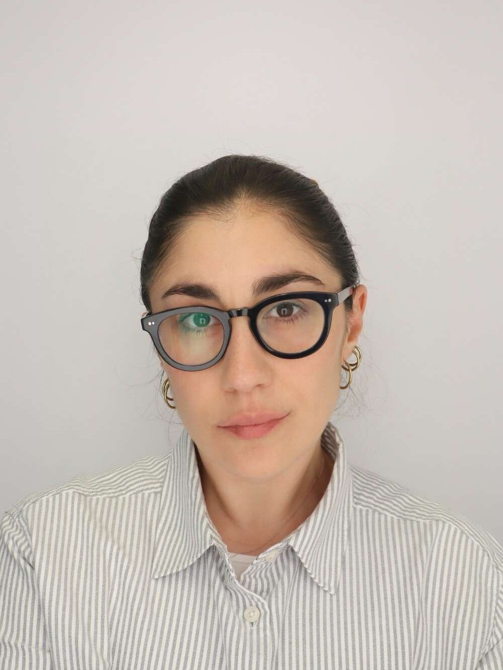 A color photo of a woman with glasses.