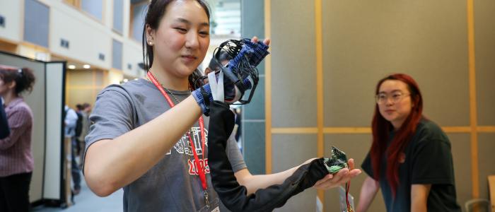 A color photo of a woman wearing a hand tracking glove.